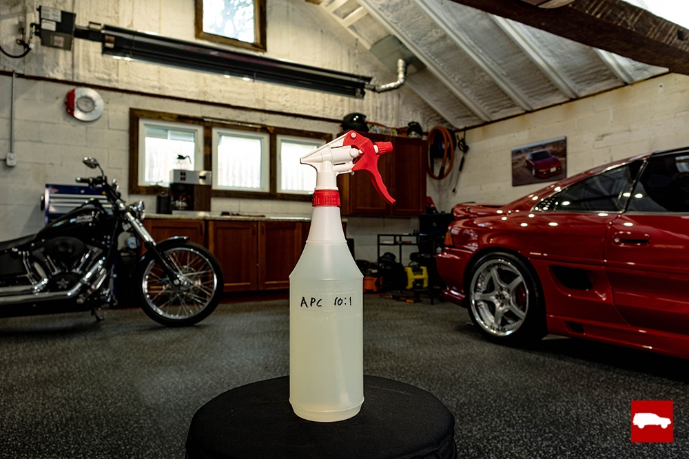 A generic bottle of all purpose cleaner on a stool in a garage
