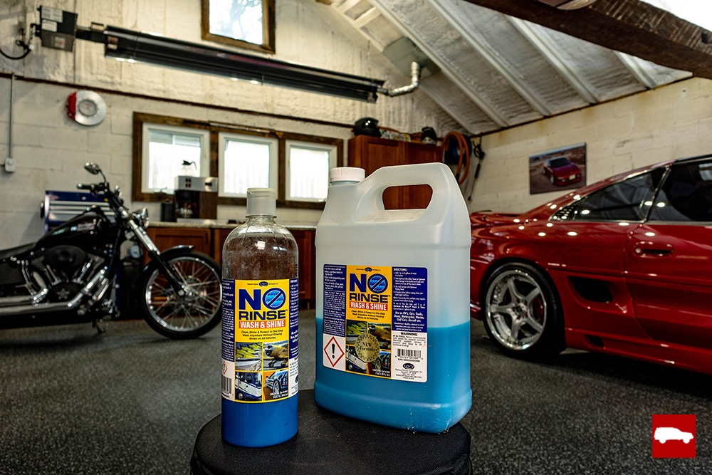 2 different sizes of Optimum No Rinse bottles on a stool in a garage